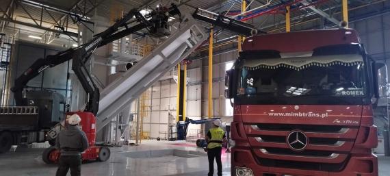 Montaż elementów lakierni do produkcji profili okiennych – praca dwóch żurawi HDS w hali przemysłowej.